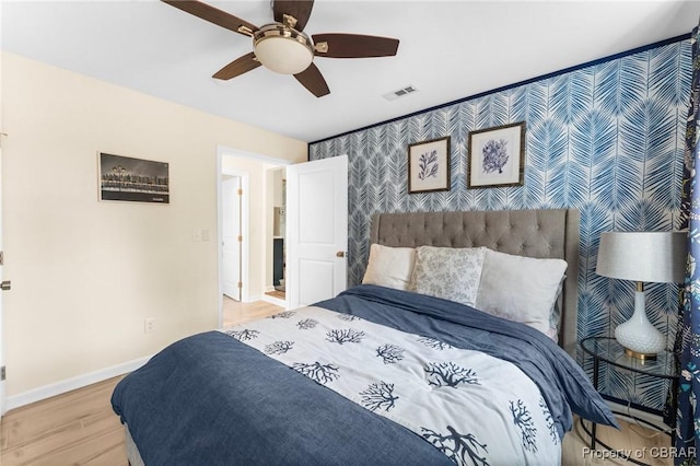 bedroom featuring wallpapered walls, baseboards, visible vents, ceiling fan, and wood finished floors