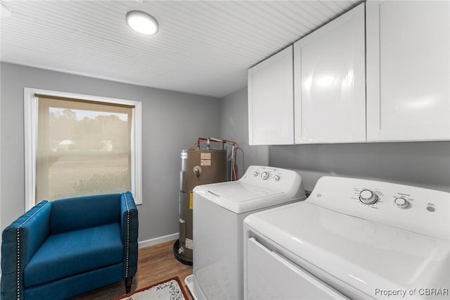 laundry area with cabinet space, electric water heater, wood finished floors, washer and dryer, and baseboards