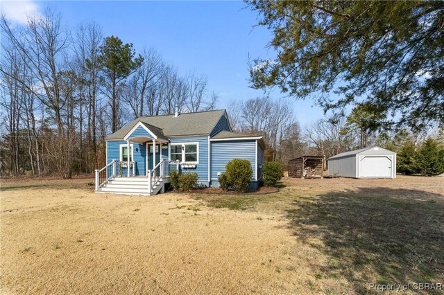 2799 Lake Rd, Lottsburg, VA 22511 - view of front of home with an outdoor structure, a detached garage, a shingled roof, and a front lawn