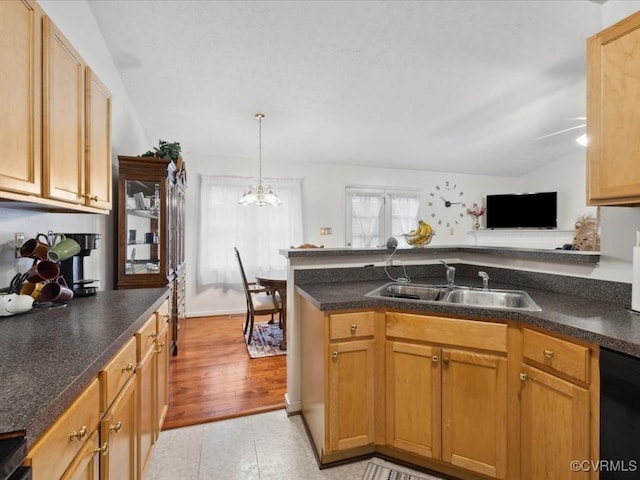 kitchen featuring dishwasher, dark countertops, lofted ceiling, a peninsula, and a sink