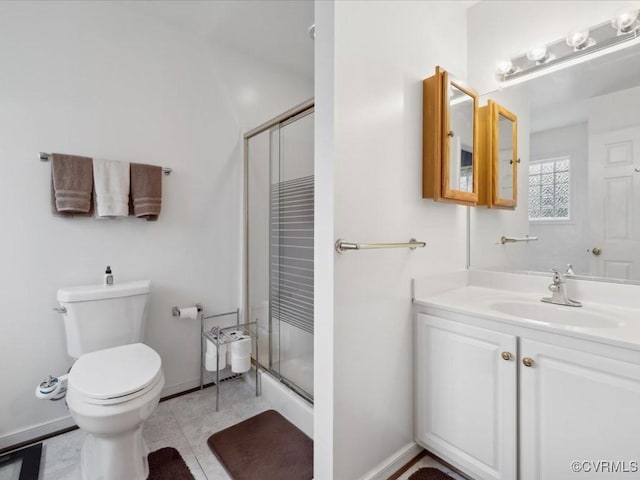 full bathroom with toilet, a stall shower, baseboards, and vanity