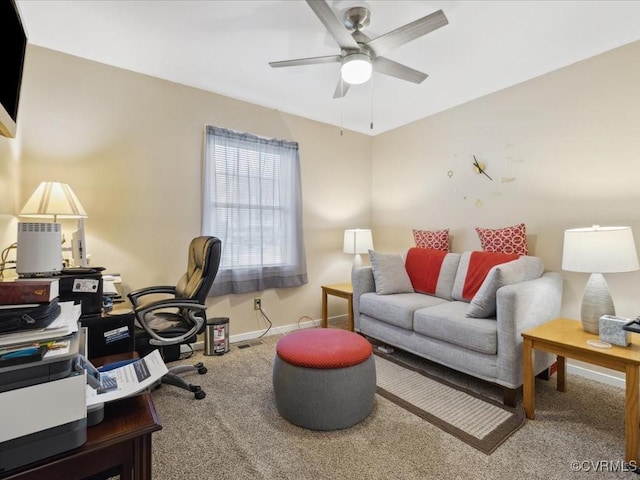 carpeted office space featuring ceiling fan and baseboards