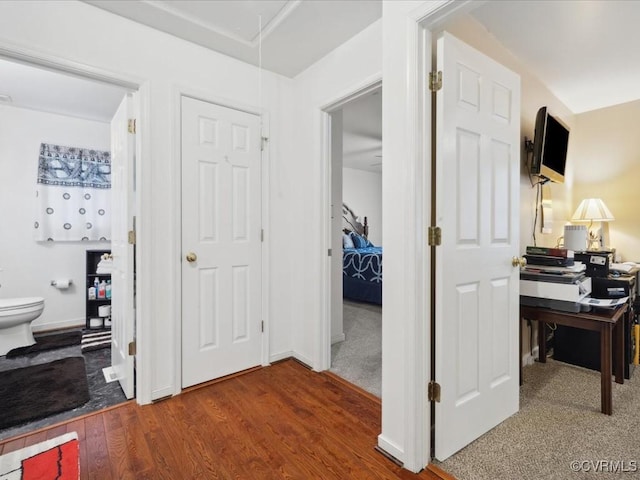 corridor with attic access, baseboards, and wood finished floors