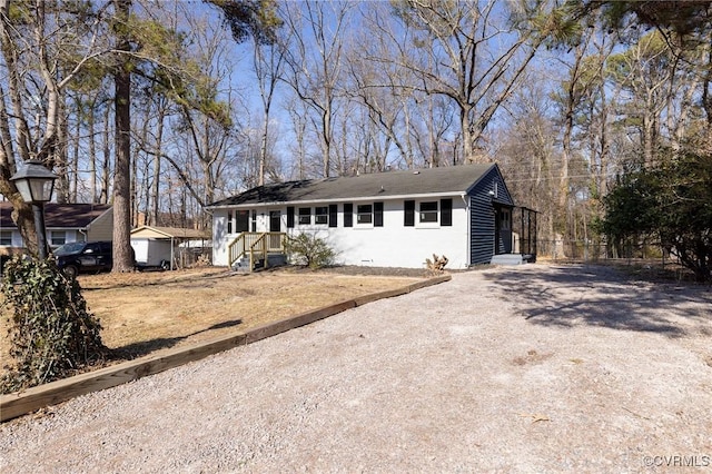 ranch-style home featuring gravel driveway