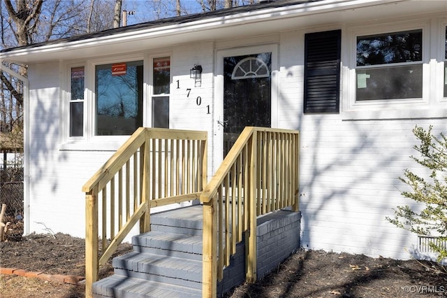 entrance to property featuring brick siding