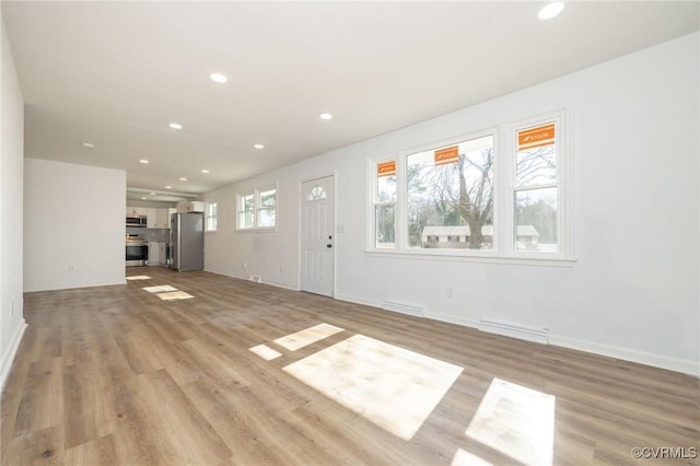 unfurnished living room featuring light wood finished floors, baseboards, visible vents, and recessed lighting