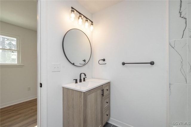 bathroom featuring vanity, baseboards, and wood finished floors