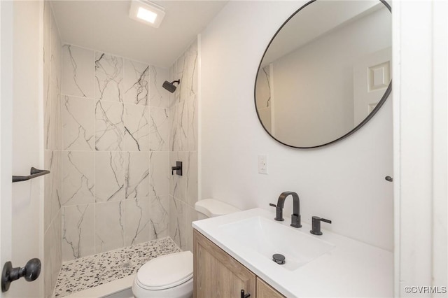 full bath featuring a stall shower, vanity, and toilet