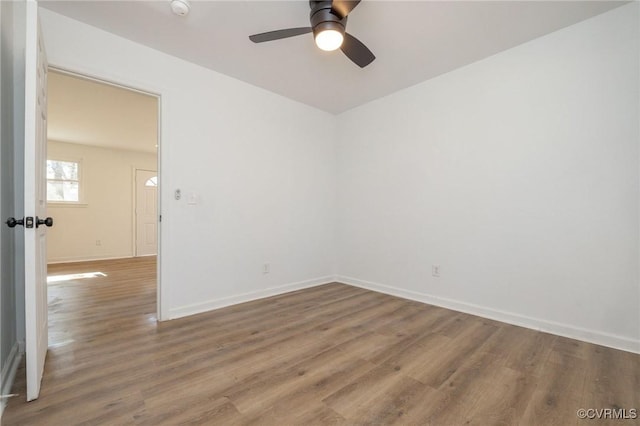 empty room featuring a ceiling fan, baseboards, and wood finished floors