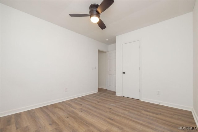 unfurnished bedroom with light wood-style flooring, baseboards, and a ceiling fan