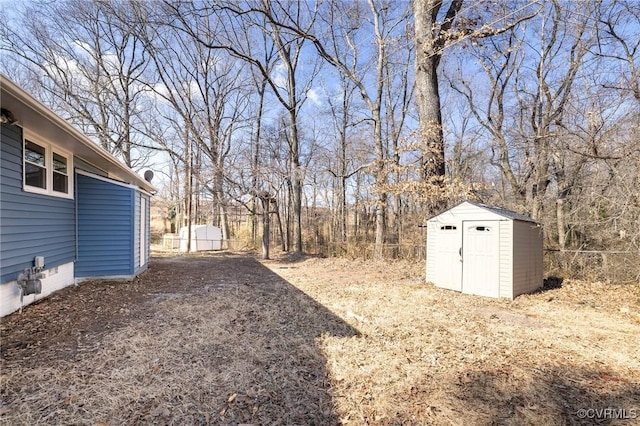 view of yard featuring an outbuilding, a storage unit, and fence