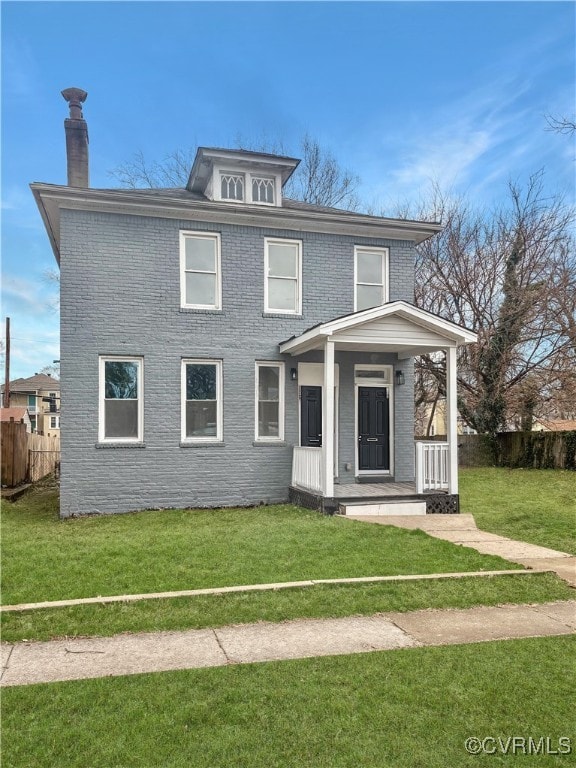 american foursquare style home featuring fence, covered porch, a chimney, a front lawn, and brick siding