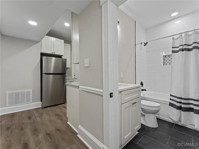 full bathroom with vanity, baseboards, visible vents, toilet, and shower / tub combo with curtain