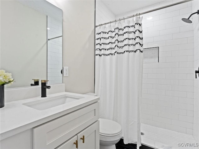 bathroom featuring toilet, vanity, and a tile shower