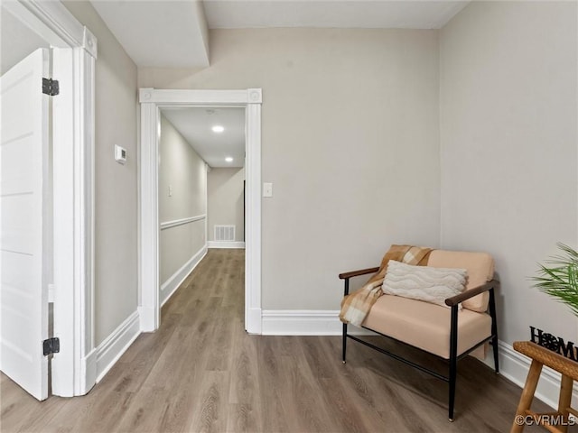 living area featuring wood finished floors, visible vents, and baseboards