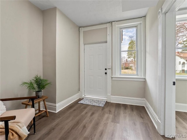 foyer entrance with wood finished floors and baseboards