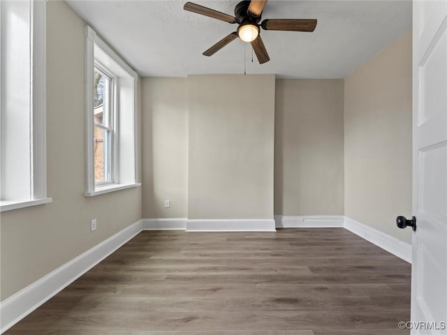 unfurnished room with a ceiling fan, wood finished floors, and baseboards