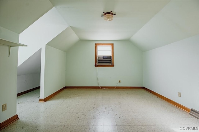 additional living space featuring cooling unit, a baseboard heating unit, baseboards, vaulted ceiling, and tile patterned floors