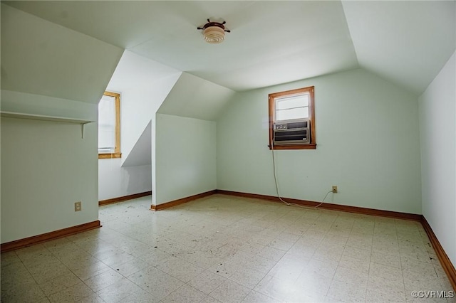 additional living space featuring cooling unit, vaulted ceiling, baseboards, and tile patterned floors