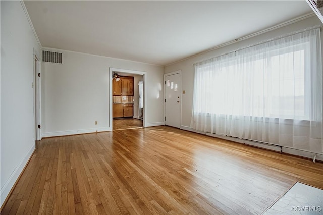 unfurnished room featuring wood-type flooring, visible vents, crown molding, and baseboards