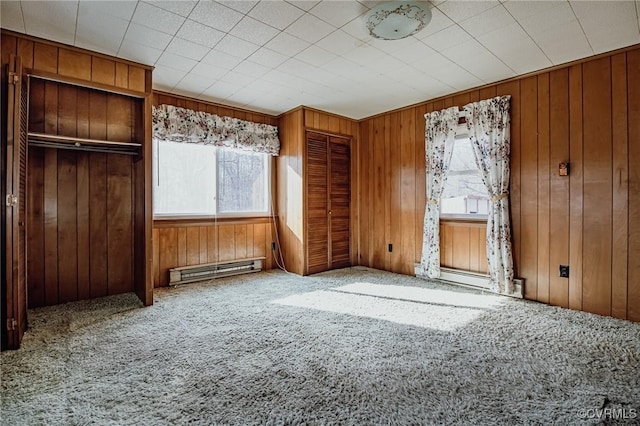 interior space featuring a baseboard heating unit and wood walls