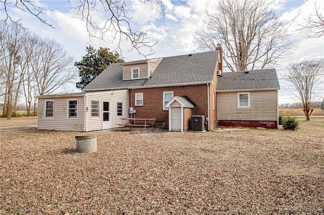 rear view of house with central AC, brick siding, and a shingled roof