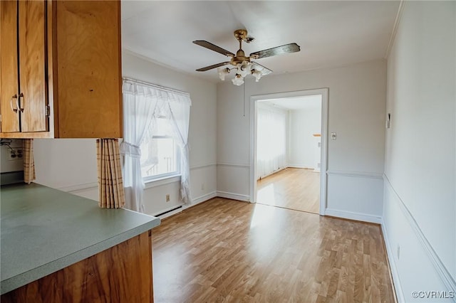 unfurnished dining area featuring light wood-style flooring, baseboards, and ceiling fan