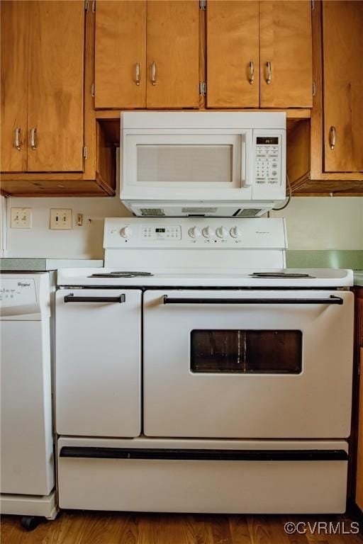 kitchen with light countertops, white appliances, and brown cabinets