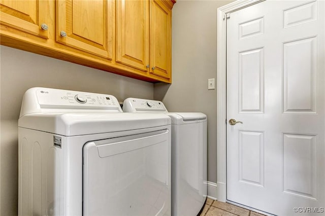 laundry area with light tile patterned floors, cabinet space, and washing machine and clothes dryer