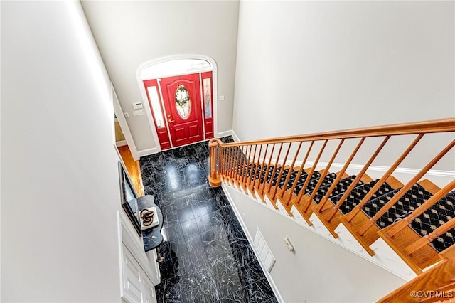 foyer entrance featuring marble finish floor and baseboards