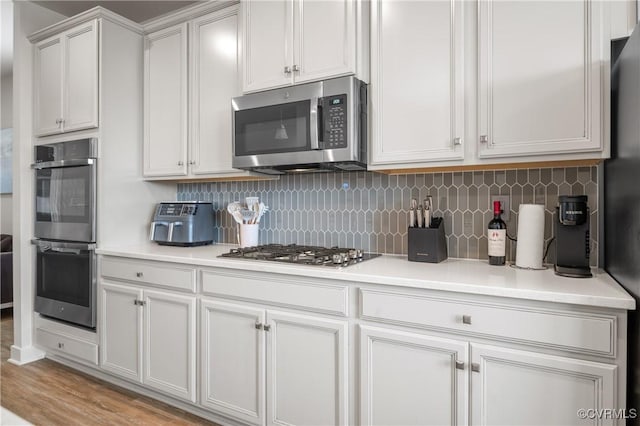 kitchen featuring appliances with stainless steel finishes, light countertops, and decorative backsplash