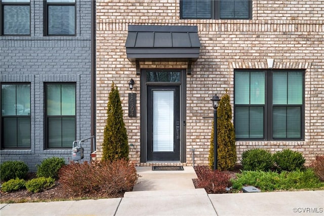 view of exterior entry featuring brick siding