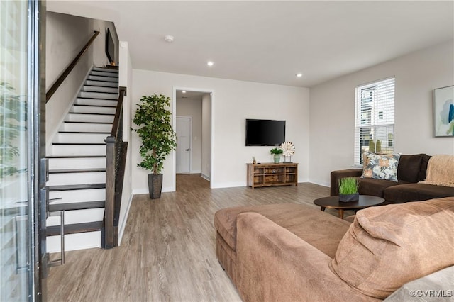 living room featuring stairs, recessed lighting, wood finished floors, and baseboards