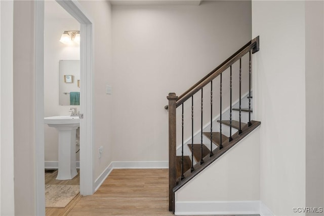 stairway featuring wood finished floors and baseboards