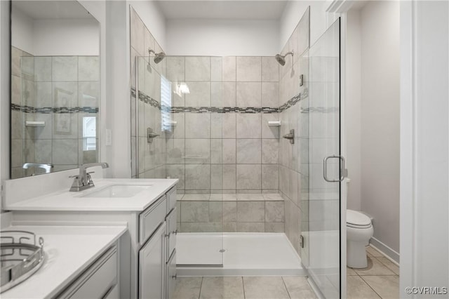 bathroom featuring a stall shower, tile patterned flooring, vanity, and toilet