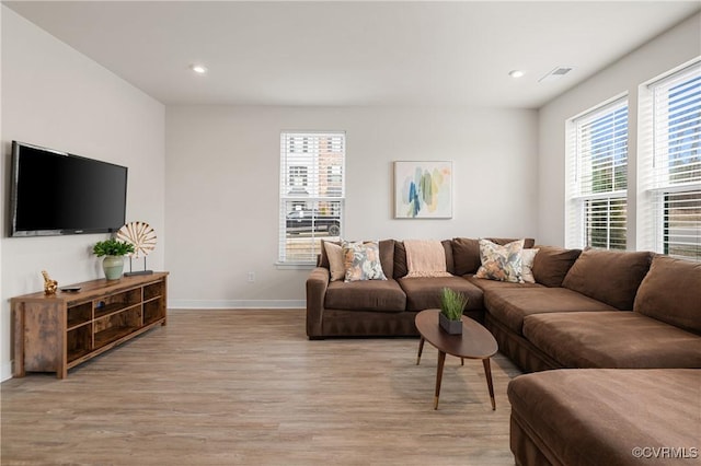 living room featuring baseboards, light wood finished floors, visible vents, and recessed lighting