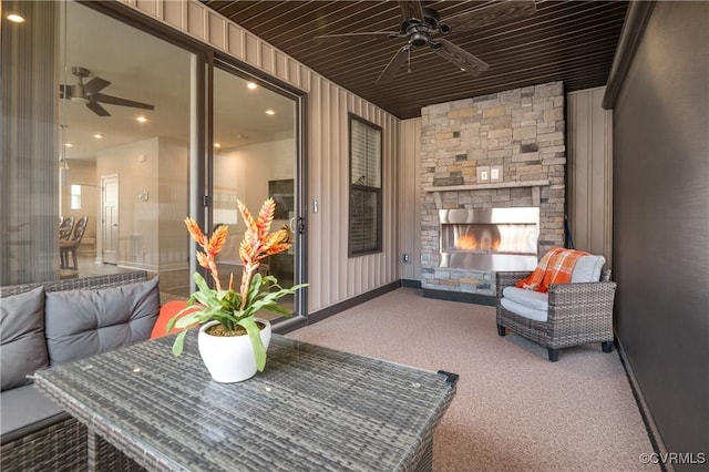 view of patio with ceiling fan and a stone fireplace