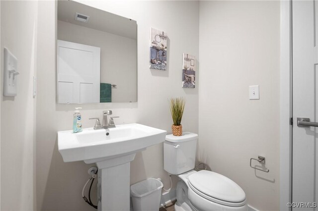 bathroom featuring toilet, visible vents, and a sink