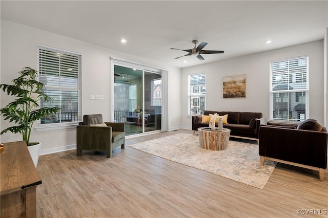 living room featuring a ceiling fan, recessed lighting, baseboards, and wood finished floors