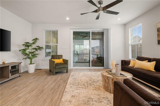 living area featuring a ceiling fan, recessed lighting, light wood-style flooring, and baseboards