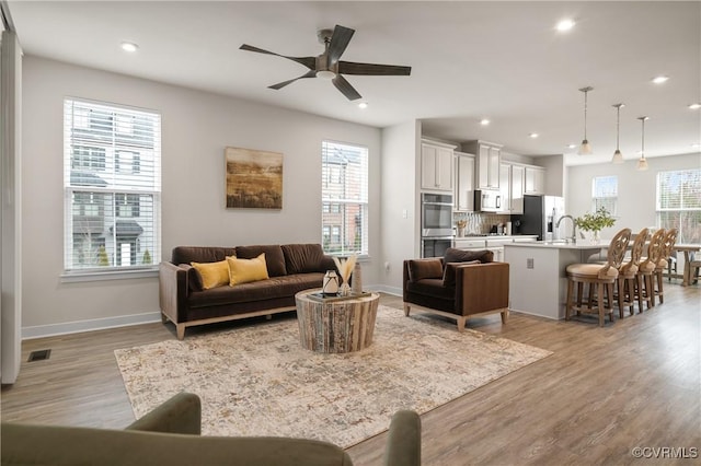 living room featuring light wood-type flooring, a wealth of natural light, and recessed lighting