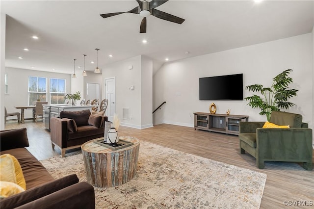 living room featuring light wood finished floors, recessed lighting, visible vents, a ceiling fan, and baseboards