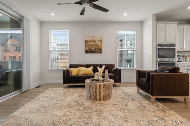 living area featuring recessed lighting, baseboards, and wood finished floors