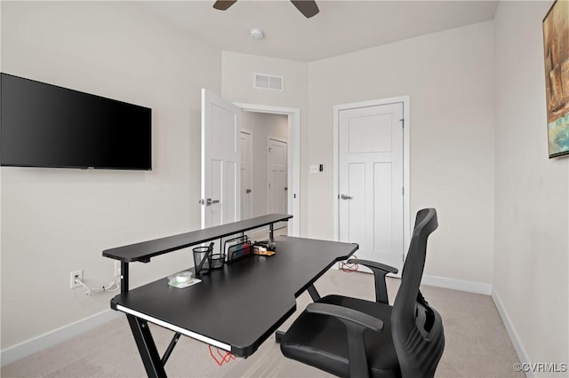 office space with ceiling fan, visible vents, baseboards, and light colored carpet