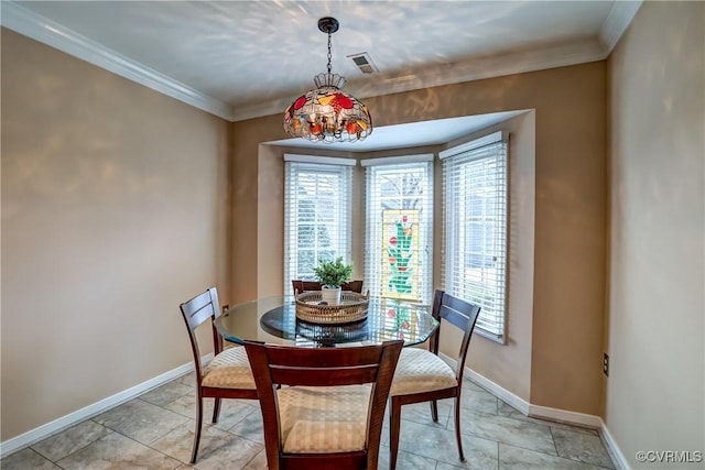 dining area featuring baseboards, visible vents, and crown molding