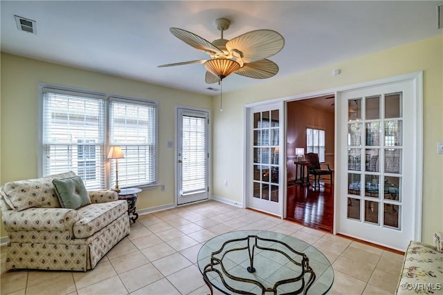 doorway to outside with ceiling fan, baseboards, visible vents, and tile patterned floors