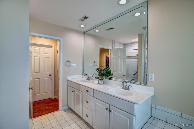 bathroom featuring visible vents, a sink, and tile patterned floors