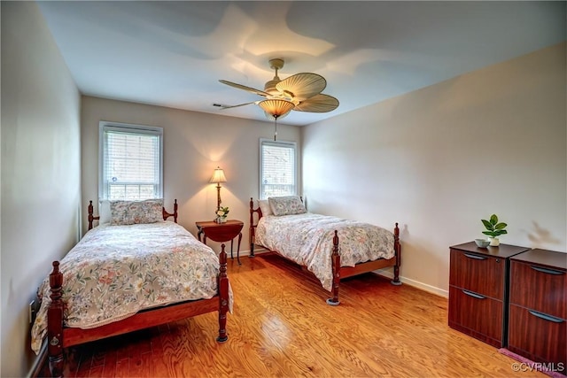 bedroom featuring light wood finished floors, multiple windows, visible vents, and baseboards