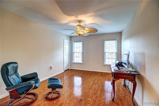 living area featuring ceiling fan, wood finished floors, and baseboards