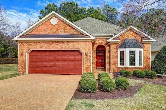 traditional home featuring metal roof, concrete driveway, and a standing seam roof